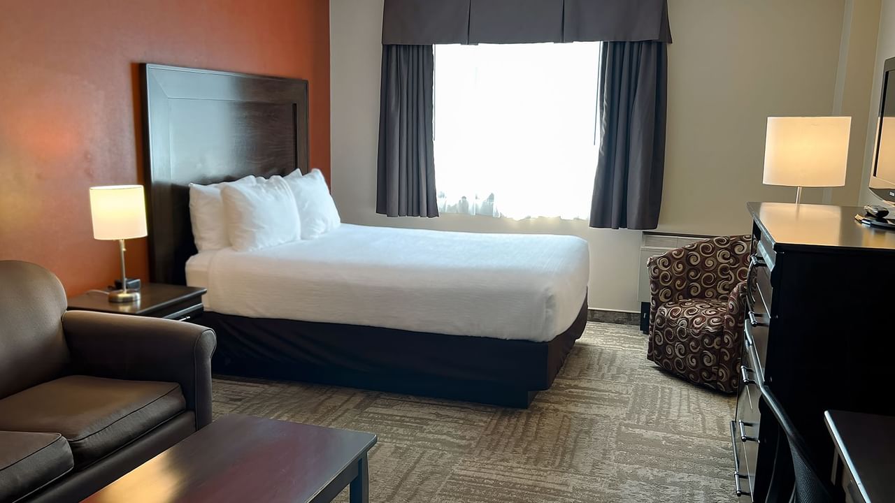 Hotel bedroom with bed, small couch, table, and sofa