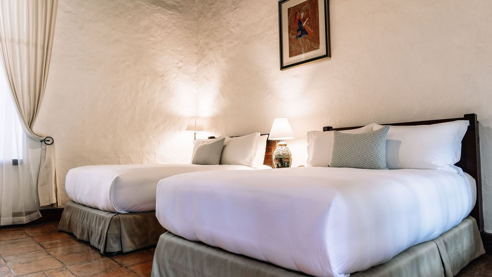 Nightstand and wall-mounted picture by the bed in 2 Double Superior Suite at Quinta Real Oaxaca