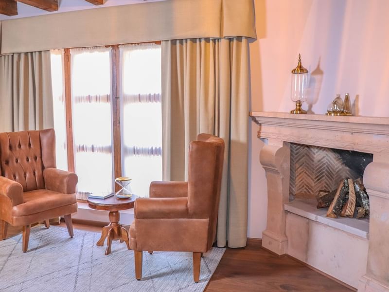 Fireplace & ancient chairs in the Deluxe Room at Gamma Hotels