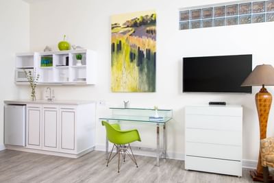 The living area of Queen Premiere Spring Fling with TV, work desk & kitchenette at Retro Suites Hotel