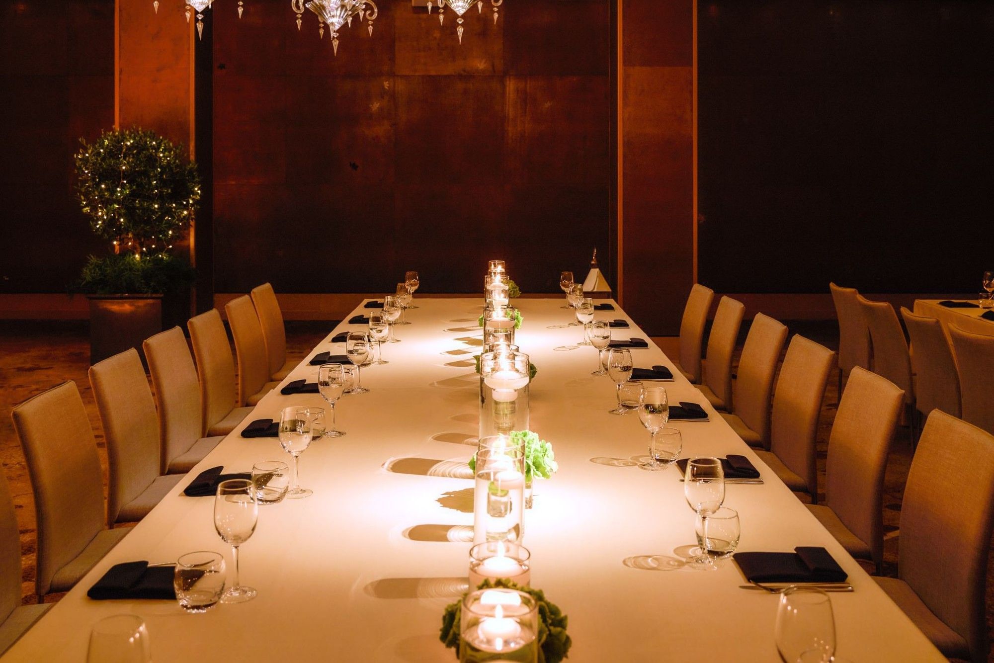 Long table set for formal dinner with candles and glassware at The May Fair Hotel, London.