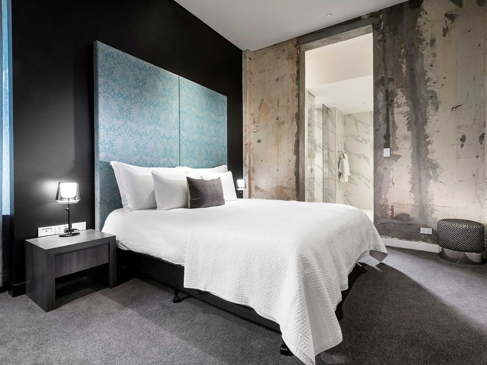 King bed and nightstand in Raw Heritage with carpeted floors at Melbourne Hotel Perth