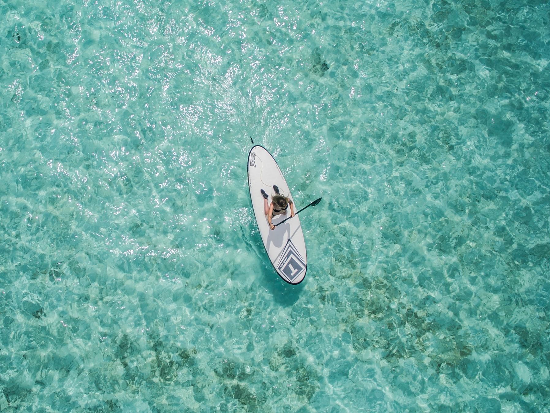 Aerial view of a person surfing with a paddle in Waikiki's Beach near Waikiki Resort Hotel