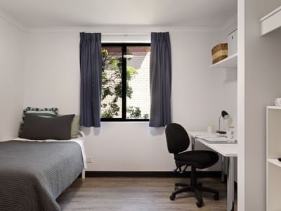 Clean and modern single bedroom with desk and window at UniLodge at Curtin University Erica Underwood House.