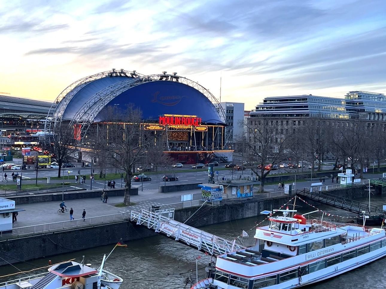 A boat on a river in front of the Moulin Rouge theater near Classic Hotel Harmonie