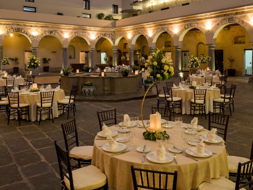 Elegantly set tables with flowers and lit candles in Patio Novicias at Quinta Real Puebla, Heroica Puebla de Zaragoza.