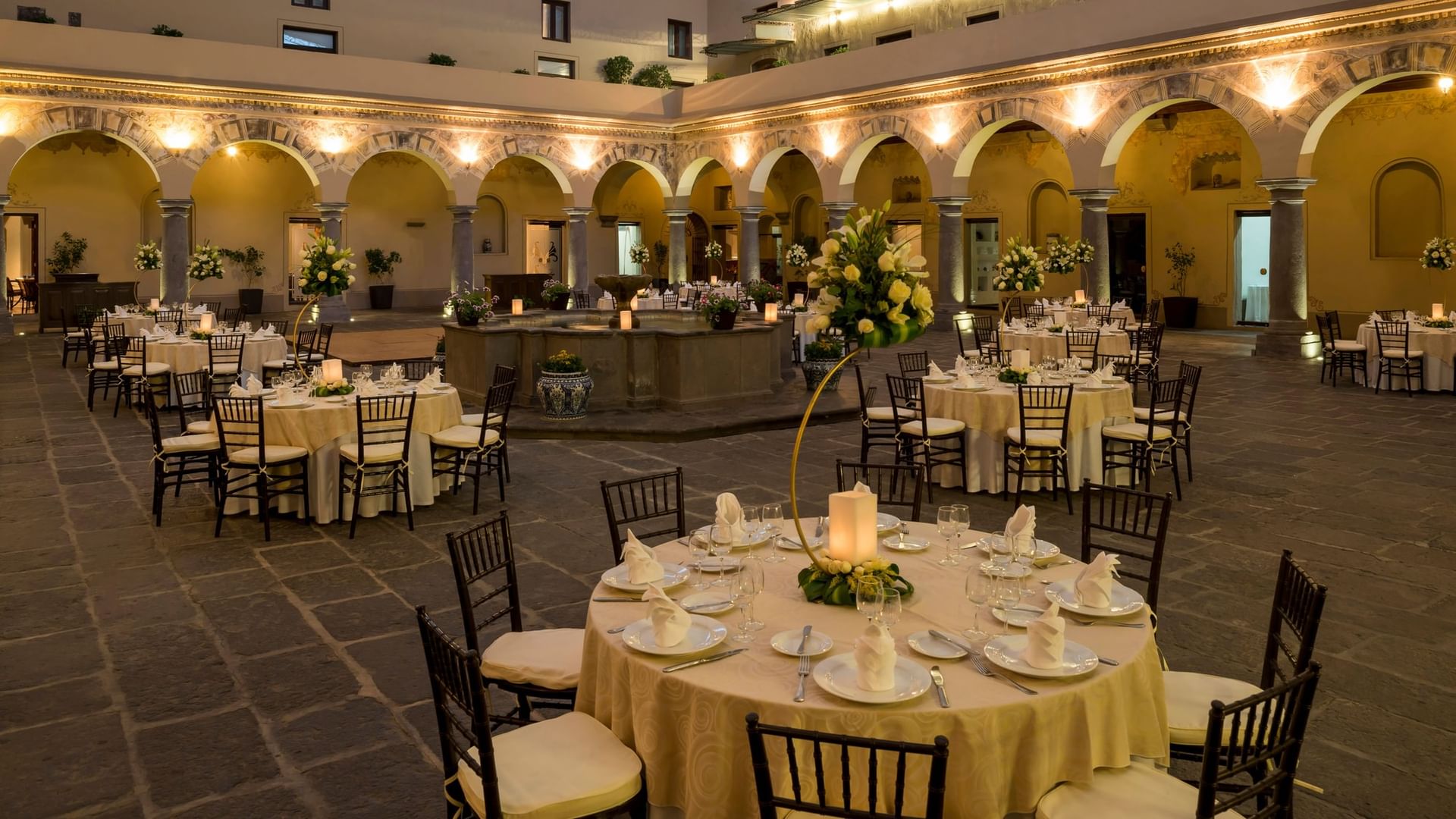 Patio Novicias decorado con mesas y sillas listas para eventos en Quinta Real Puebla Heroica Puebla de Zaragoza