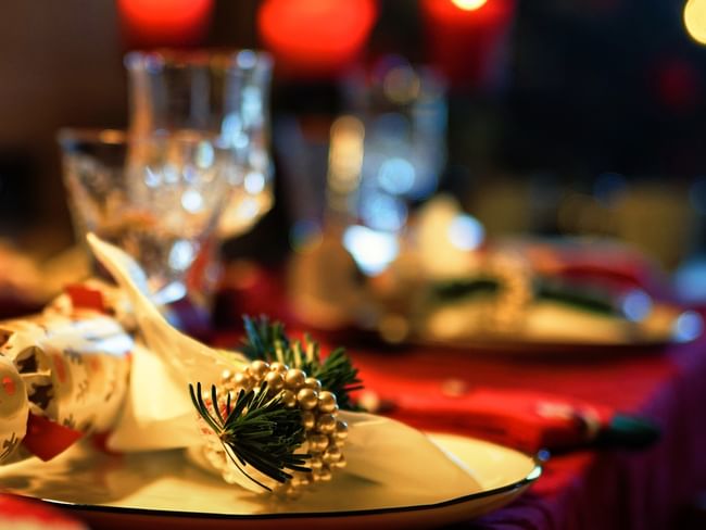 Festive table setting with wine glasses and a Christmas napkin ring for the Christmas Eve Buffet.