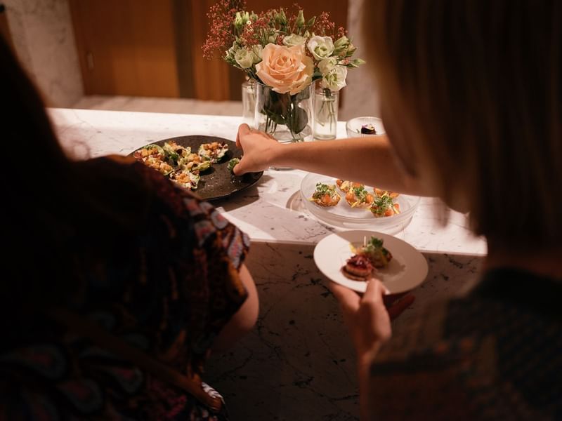 Ladies snacking on appetizers in a function held at Almanac X Alcron Prague, Fine Dining Prague