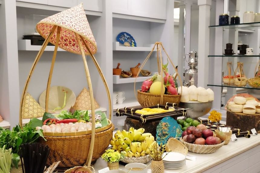 Vibrant display of fresh fruits and vegetables in woven baskets, alongside various traditional items at Park Hyatt Saigon