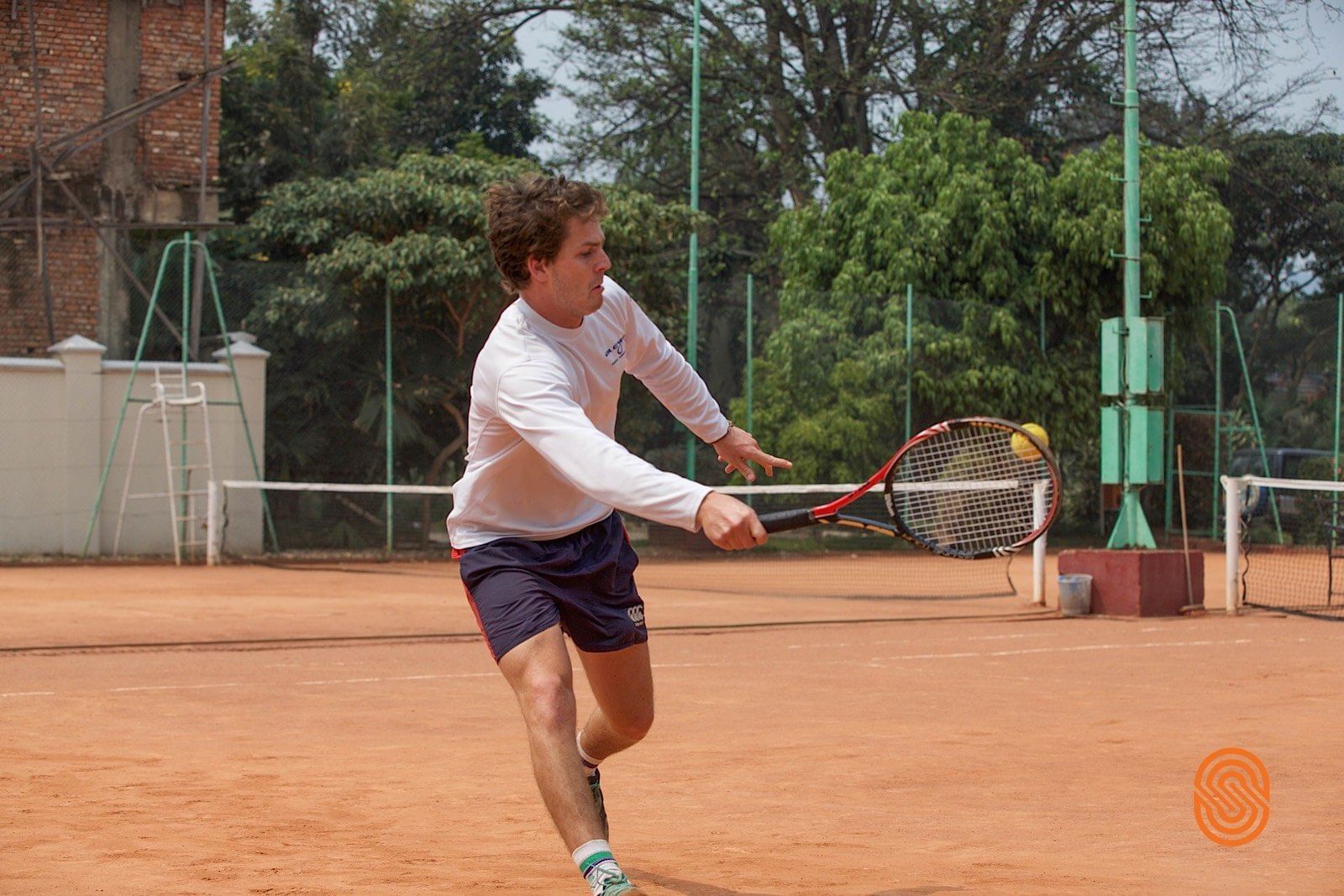 A Man playing tennis at Lake kivu Serena Hotel