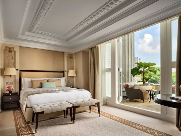 Bed and benches by the balcony in Quay Pool View Room at The Fullerton Hotel Singapore