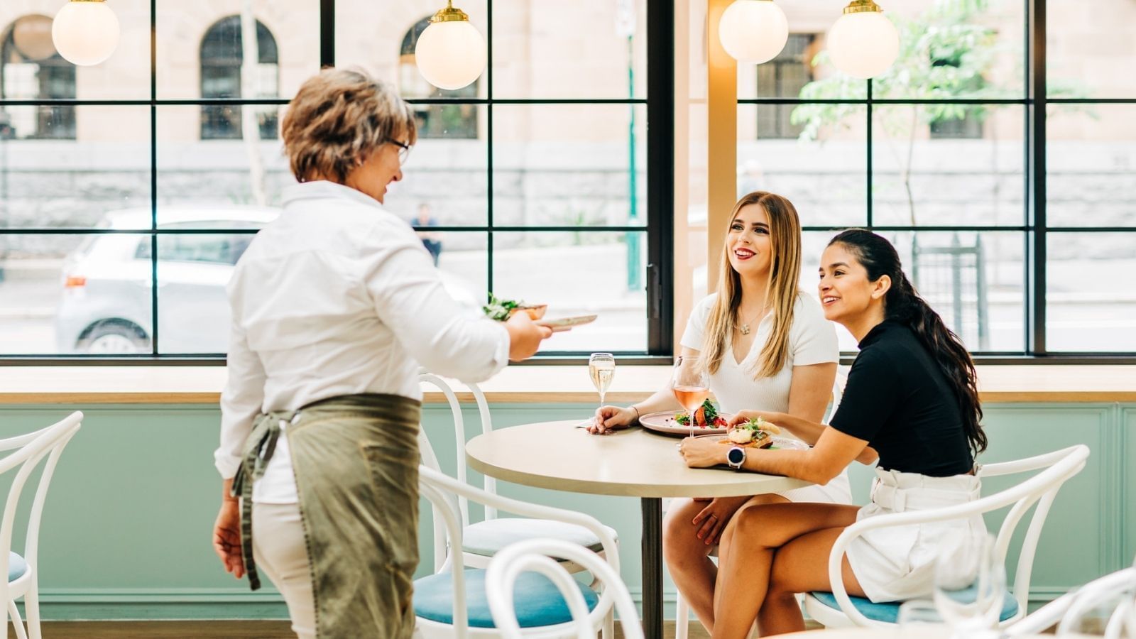 A waiter serving food to the customers in a restaurant at Pullman King George Square