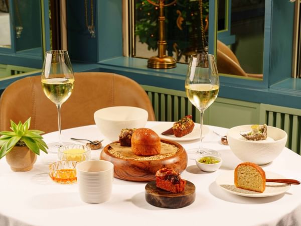 Elegant dining table with wine glasses, dishes, and bread at The Capital Hotel, Apartments & Townhouse - London.
