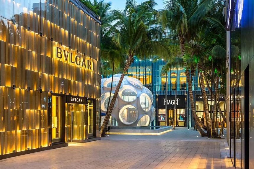Luxurious mall with high-end shops, palm trees, and modern architecture at 27 Wynwood.