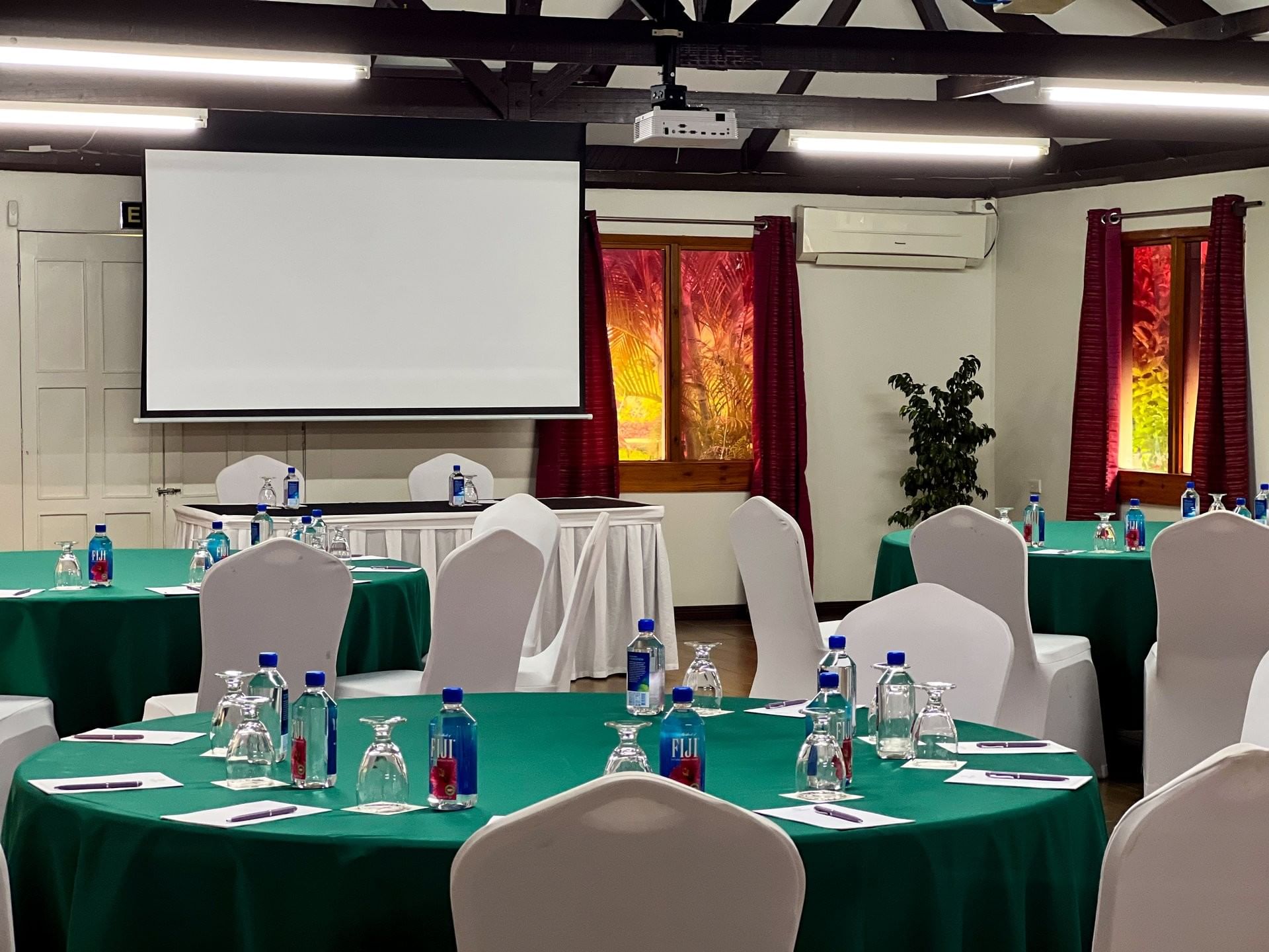 Meeting room with green tables and white chairs under a projector screen at TokaToka Resort Nadi Fiji