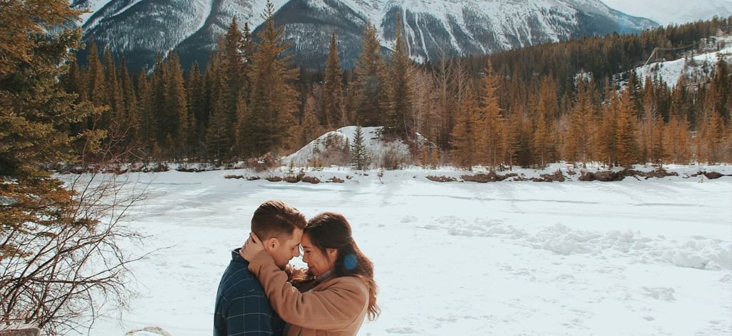 Two people embrace while on a weekend getaway in Canmore.