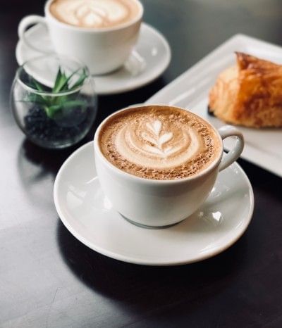Decorative lattes sitting on a table at one of the best relaxing cafes in Orlando near Rosen Inn International.