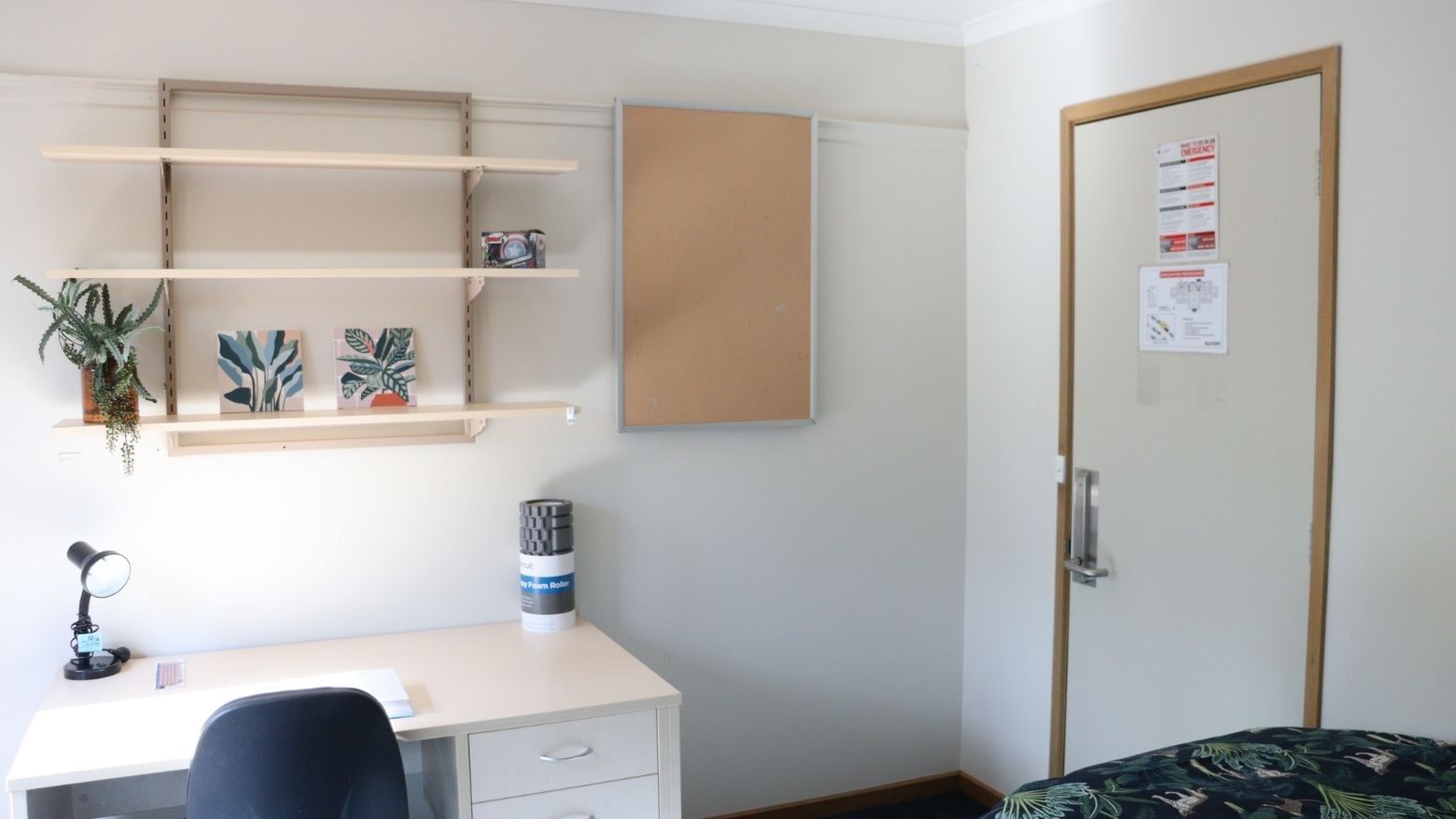White room with desk, chair, shelf, and bed at La Trobe University - Terraces.