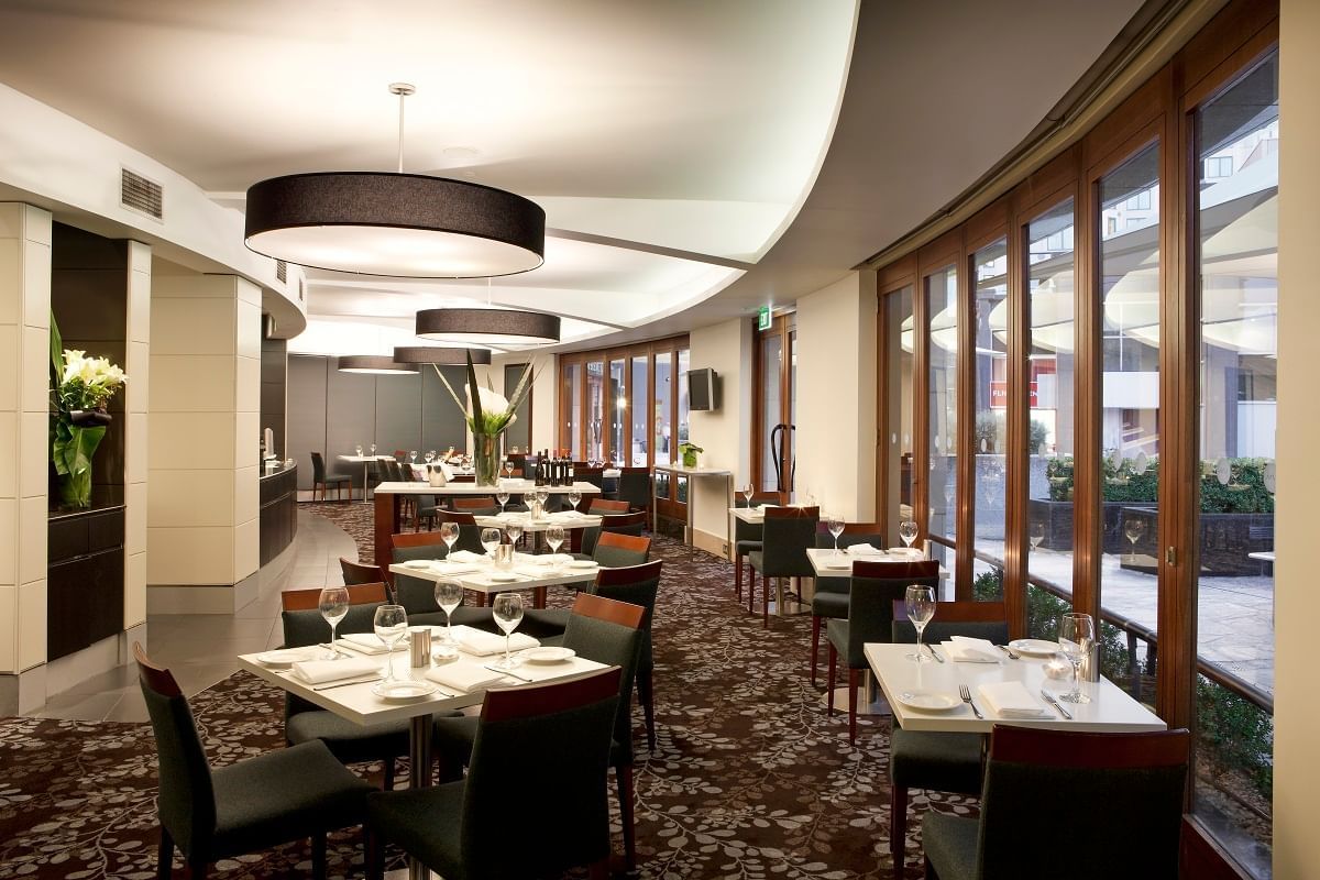 Indoor dining tables arranged in Jarrah Bar & Terrace at Quay West Suites Melbourne