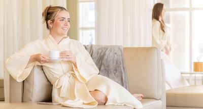 women in robe drinking tea