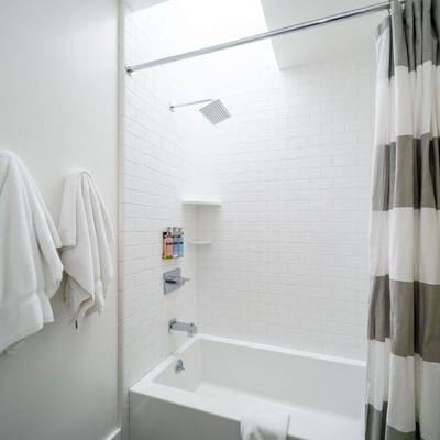 Shower area and tub with amenities in Deluxe King Room at Becks Motor Lodge San Francisco California