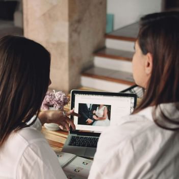 Two women review a wedding photo on a laptop at The Saujana Hotel Kuala Lumpur