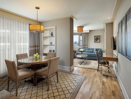 Titanic City Taksim suite's living room with a dining table, couch, desk, and chair.