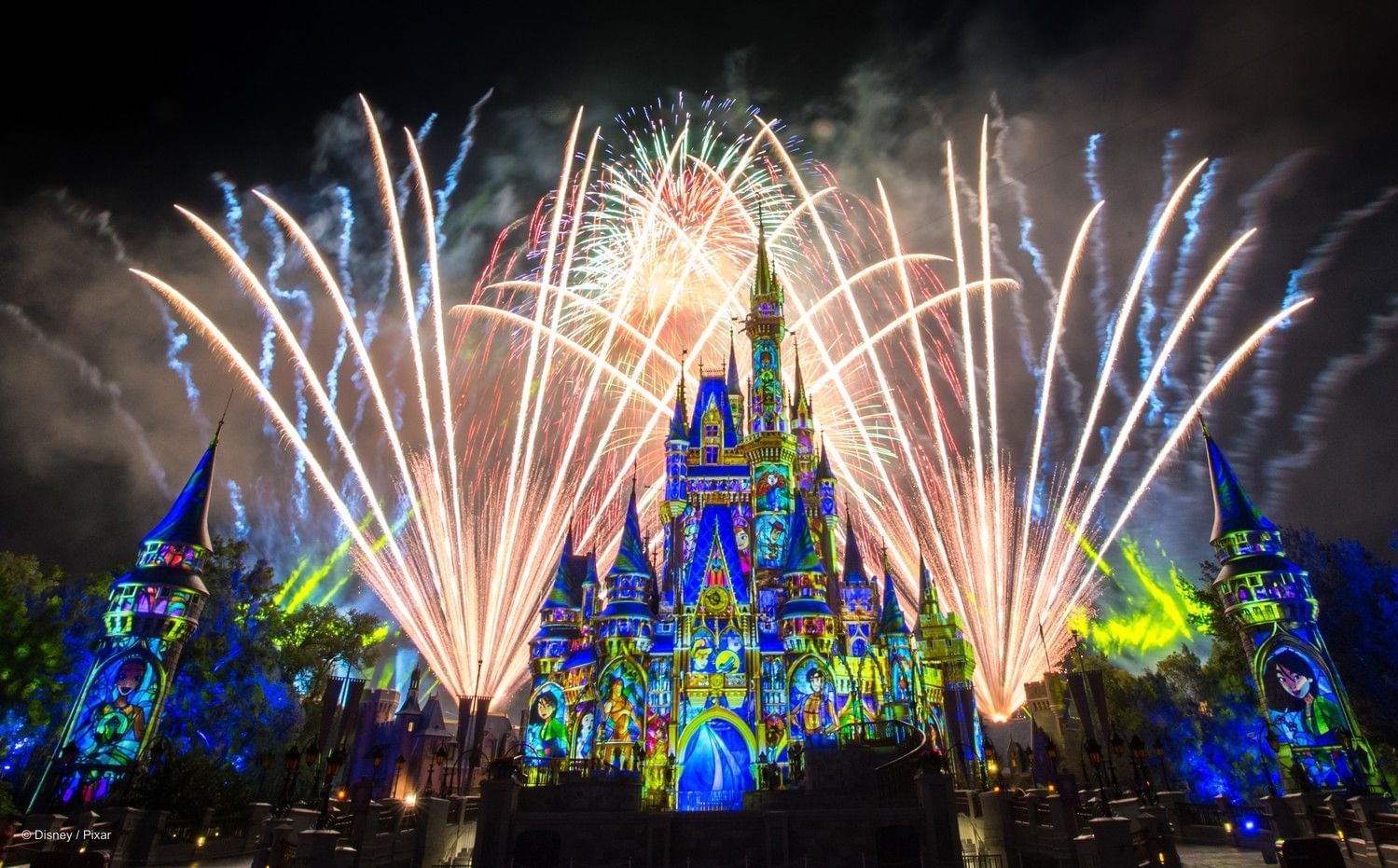 A spectacular display of fireworks against the night sky with projections across a beautiful fairy tale castle. 