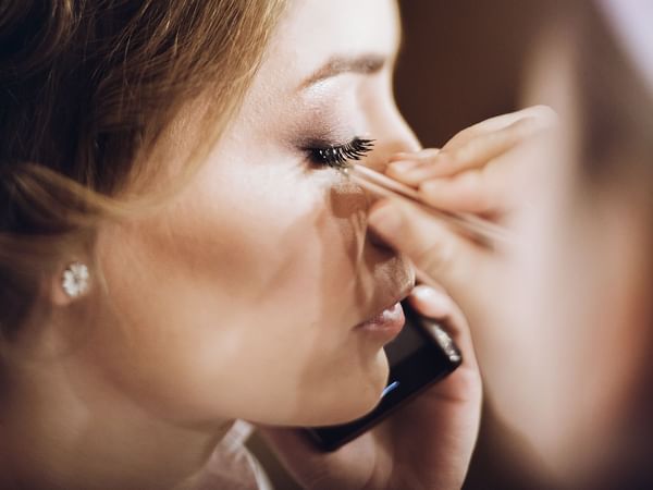 Close-up of lady applying makeup at Warwick Melrose Dallas