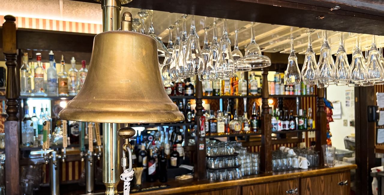 Bar with glasses, a bell, and bottles of alcohol