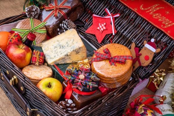 Christmas hamper with seasonal goods including cheese, wine and wrapped presents