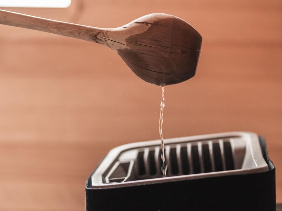 A wooden spoon pouring water into plastic box, Originals Hotels