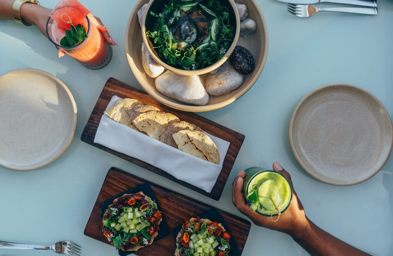Overhead view of colorful dishes and drinks at Mi Amor's restaurant