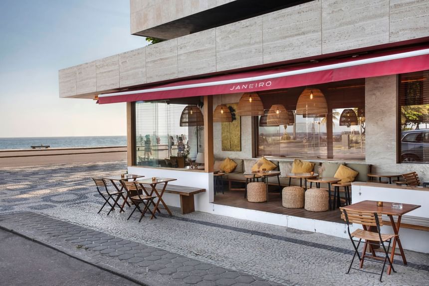 Janeiro Bar no Leblon de frente para o mar com decoração de mesas, cadeira almofadas e luminárias  com estilo praiano e moderno