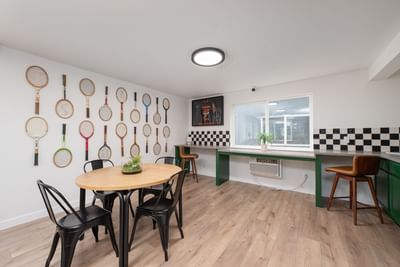 Minimalist room with wooden floors & a wall displaying tennis rackets at Varsity North, one of the top Centralia, WA hotels
