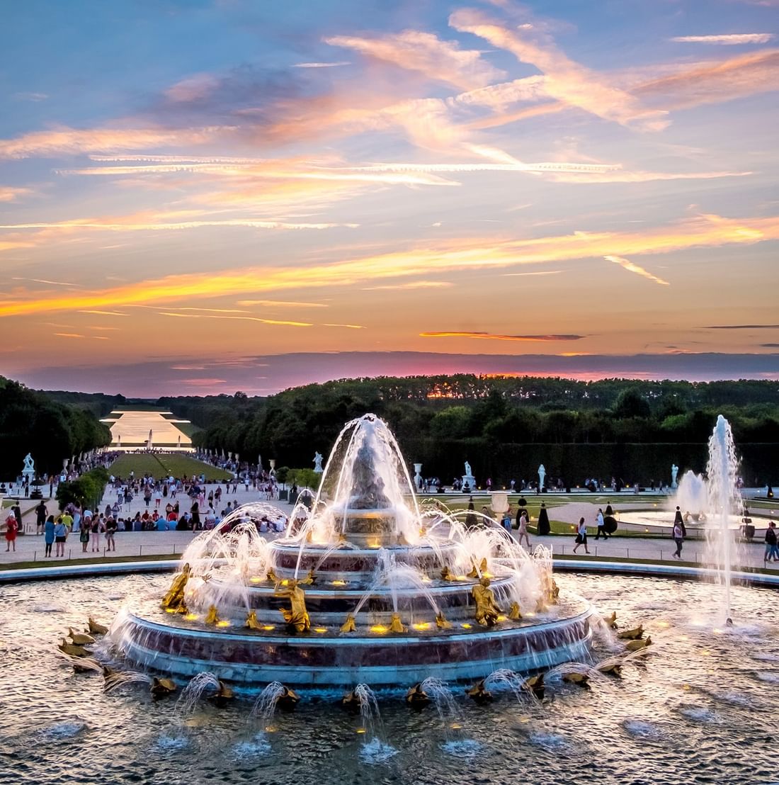 Fontaine ornementale de Versailles illuminée au coucher du soleil avec jardins et visiteurs à Hotel Westminster Warwick Paris