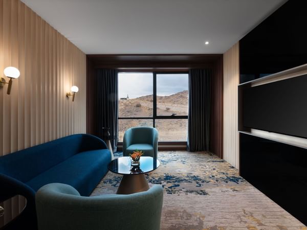 Interior of the living area with a sofa facing the TV  at Warwick Hotel Al Taif