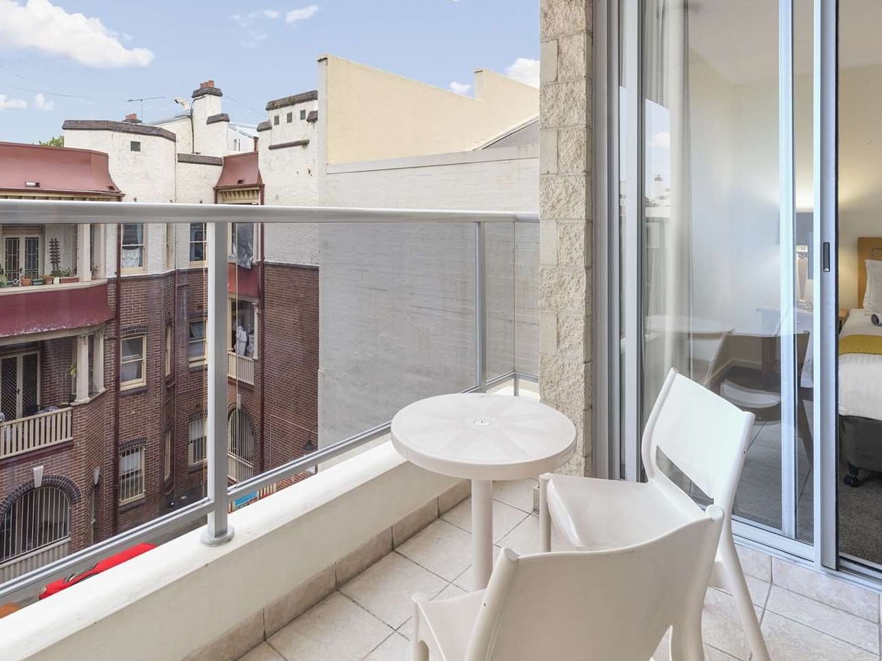 Chairs arranged with table on the balcony at Nesuto Chippendale Apartment Hotel