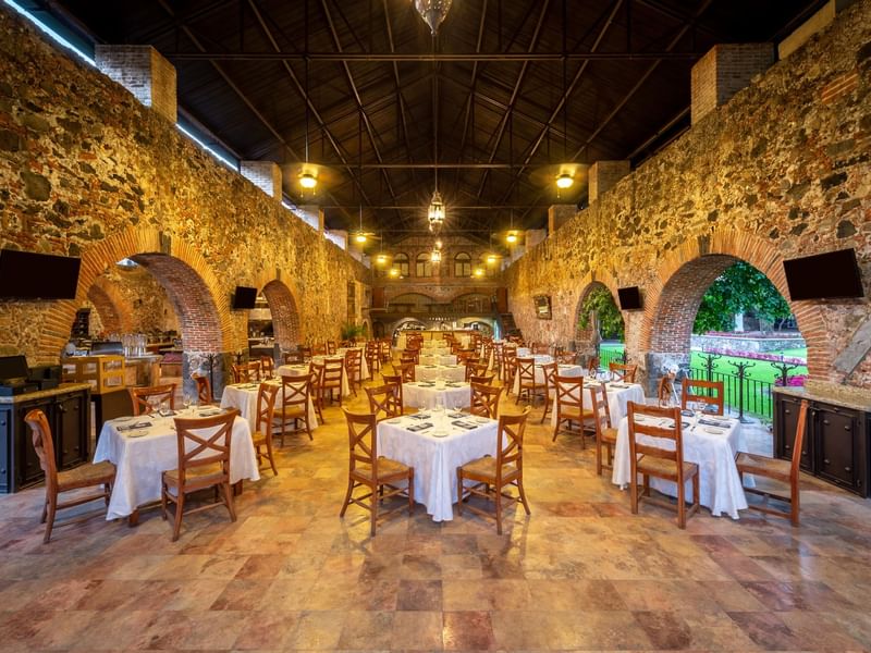 Dining table arrangement in a hall with arches at Fiesta Americana