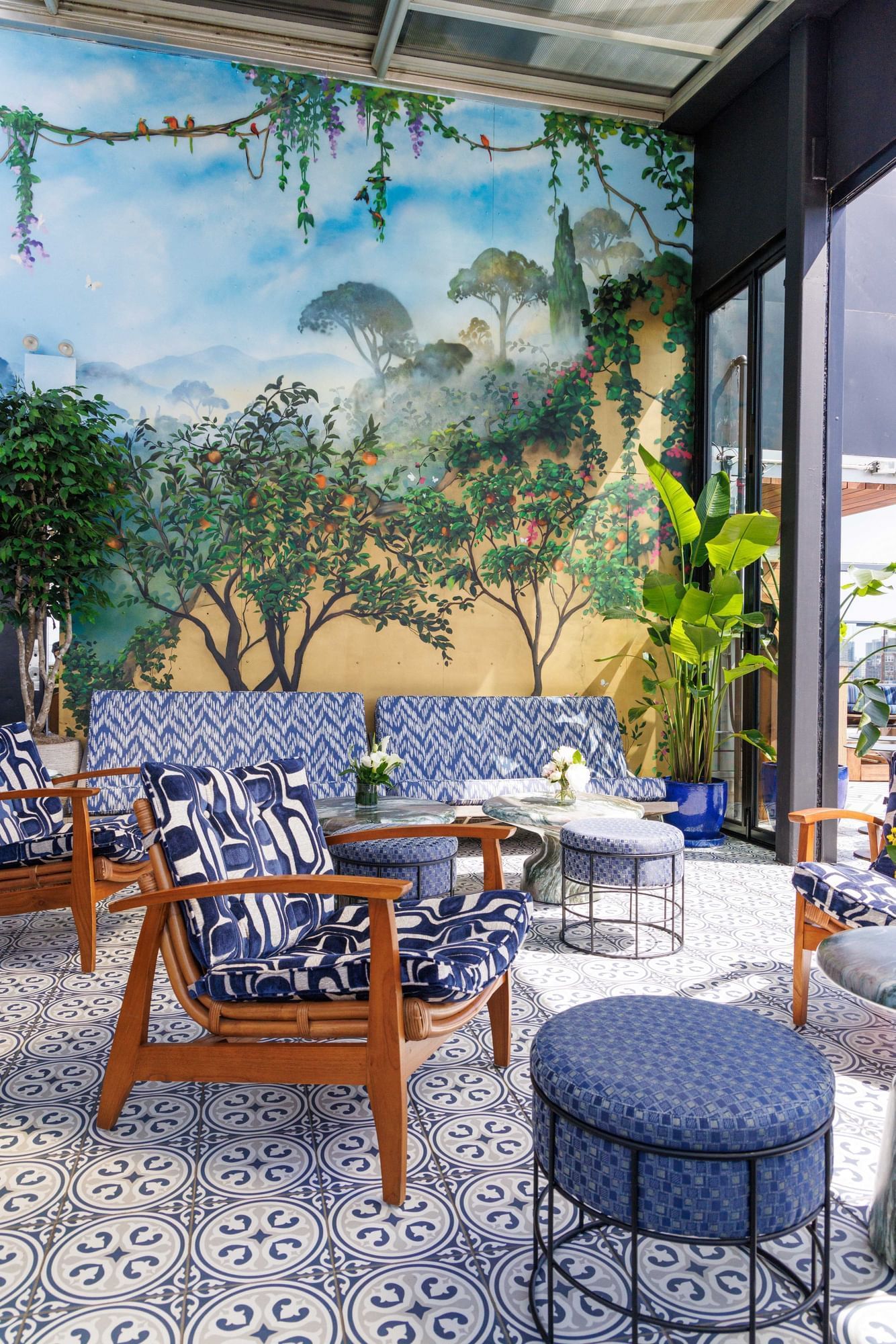 Gansevoort rooftop with blue furniture and a mural on the wall