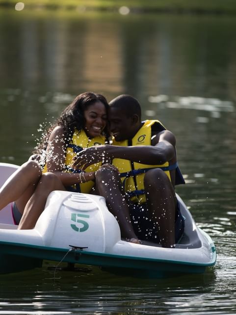 Couple having a laugh while enjoying the pedal boat ride on the Lake near Cove Pocono Resorts