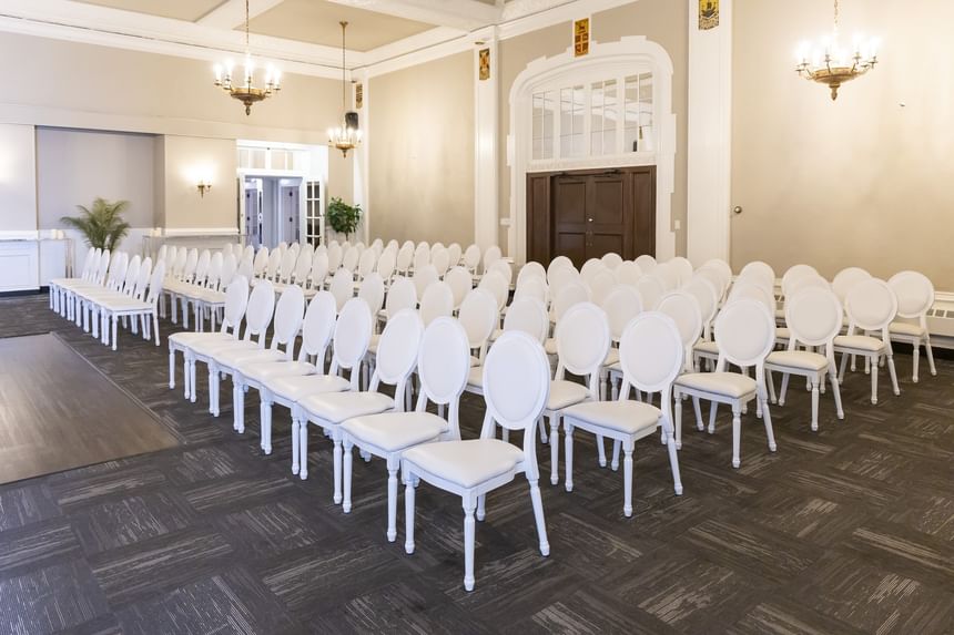 White chairs arranged in rows under classic chandeliers at Rodd Charlottetown Hotel, a featured Charlottetown event venues