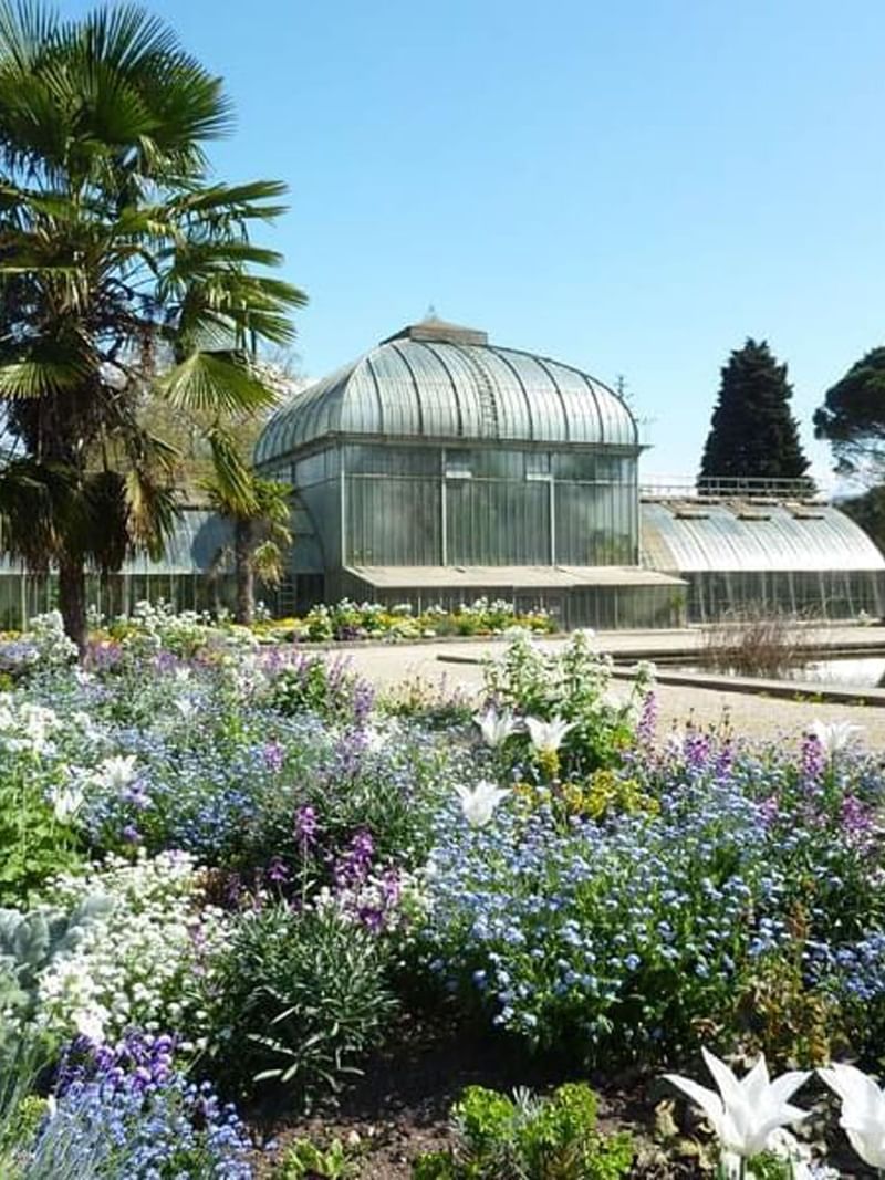 Jardin Botanique with Glass conservatory by a pond surrounding flower beds near Warwick Geneva