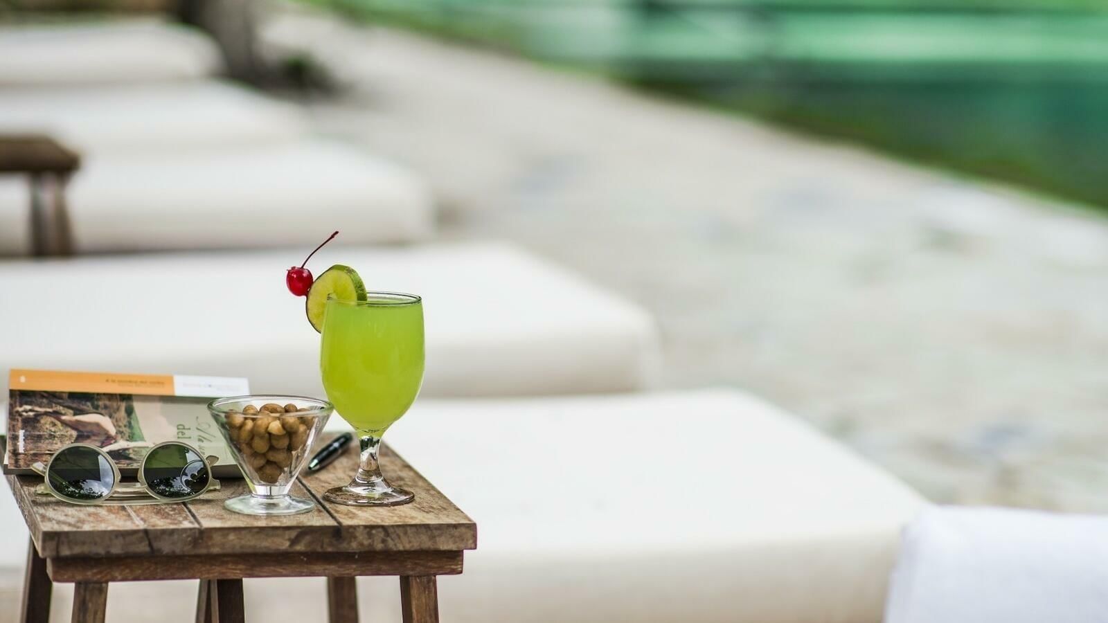 Cocktail & a bowl of nuts served by the outdoor pool at The Explorean Cozumel