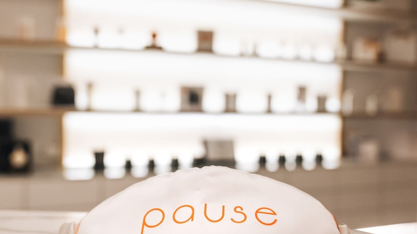 White sleep mask with orange Pause Spa logo on a marble counter at Paramount Hotel Dubai