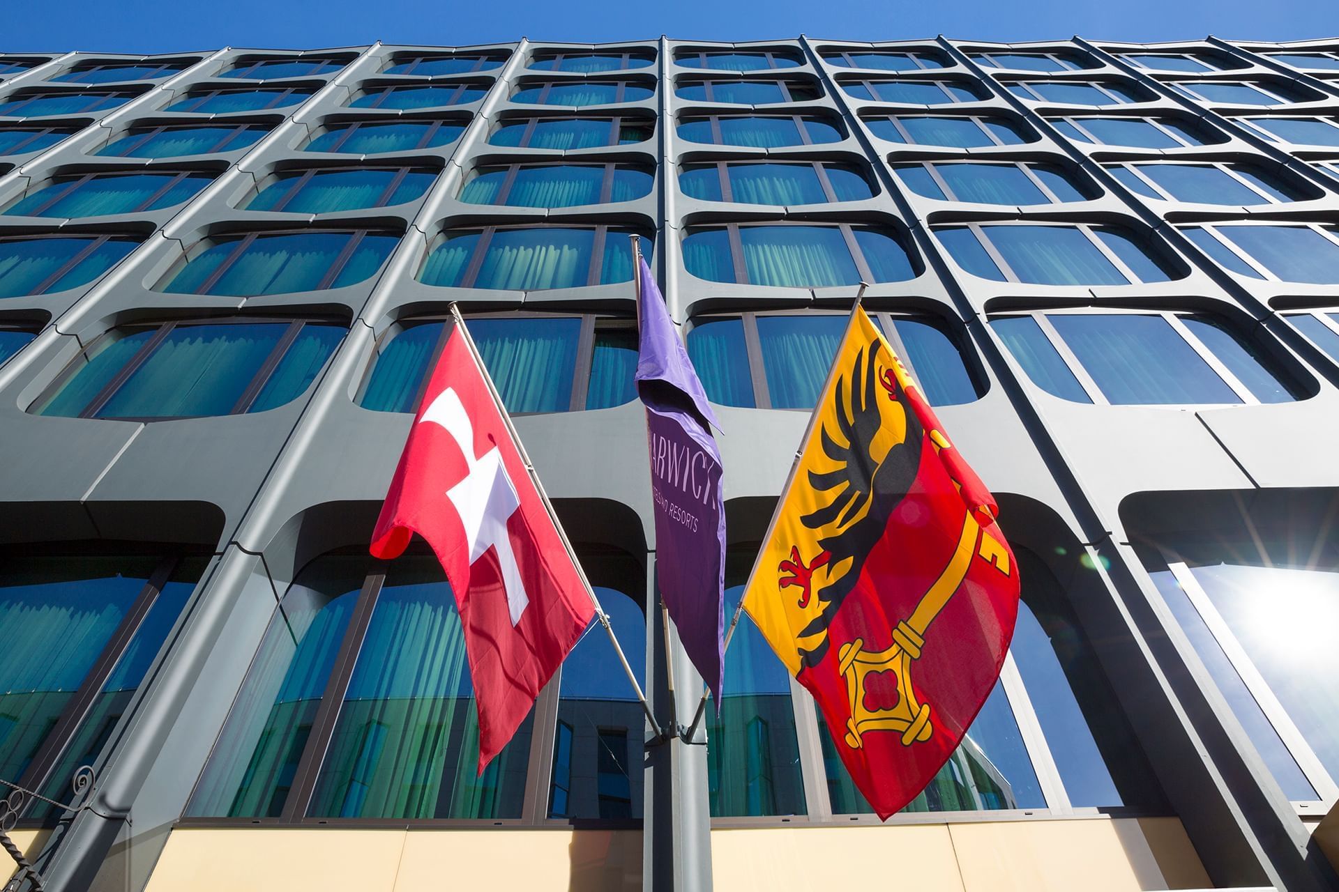 Façade du Warwick Geneva avec drapeaux