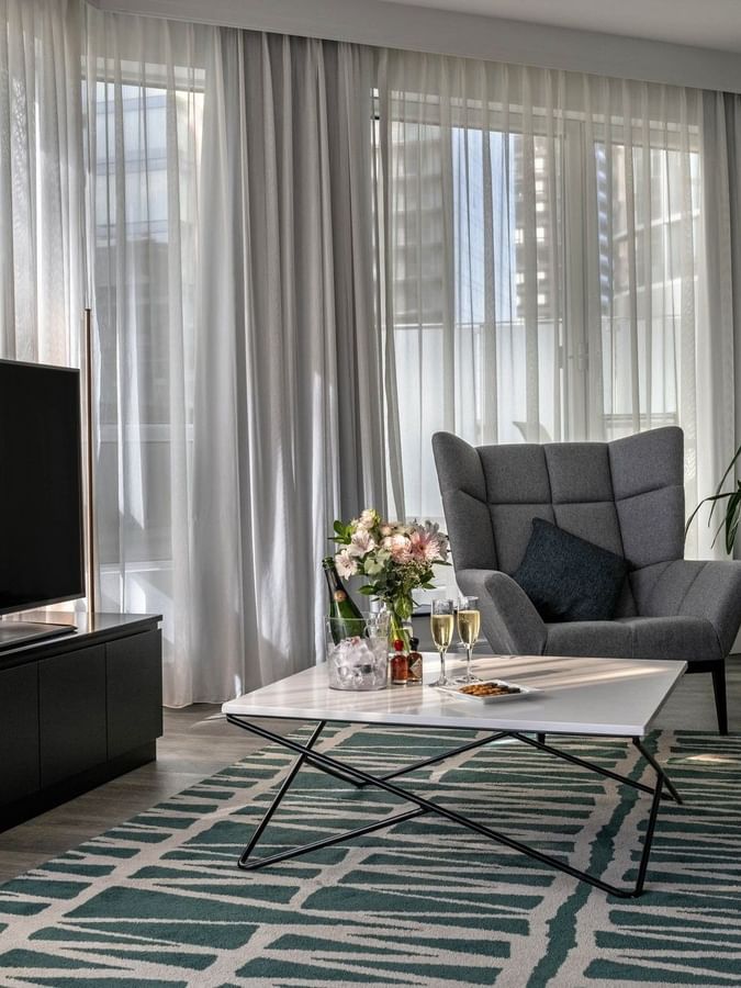 Salon élégant avec mobilier moderne et télévision à écran plat au Warwick Le Crystal – Montréal.