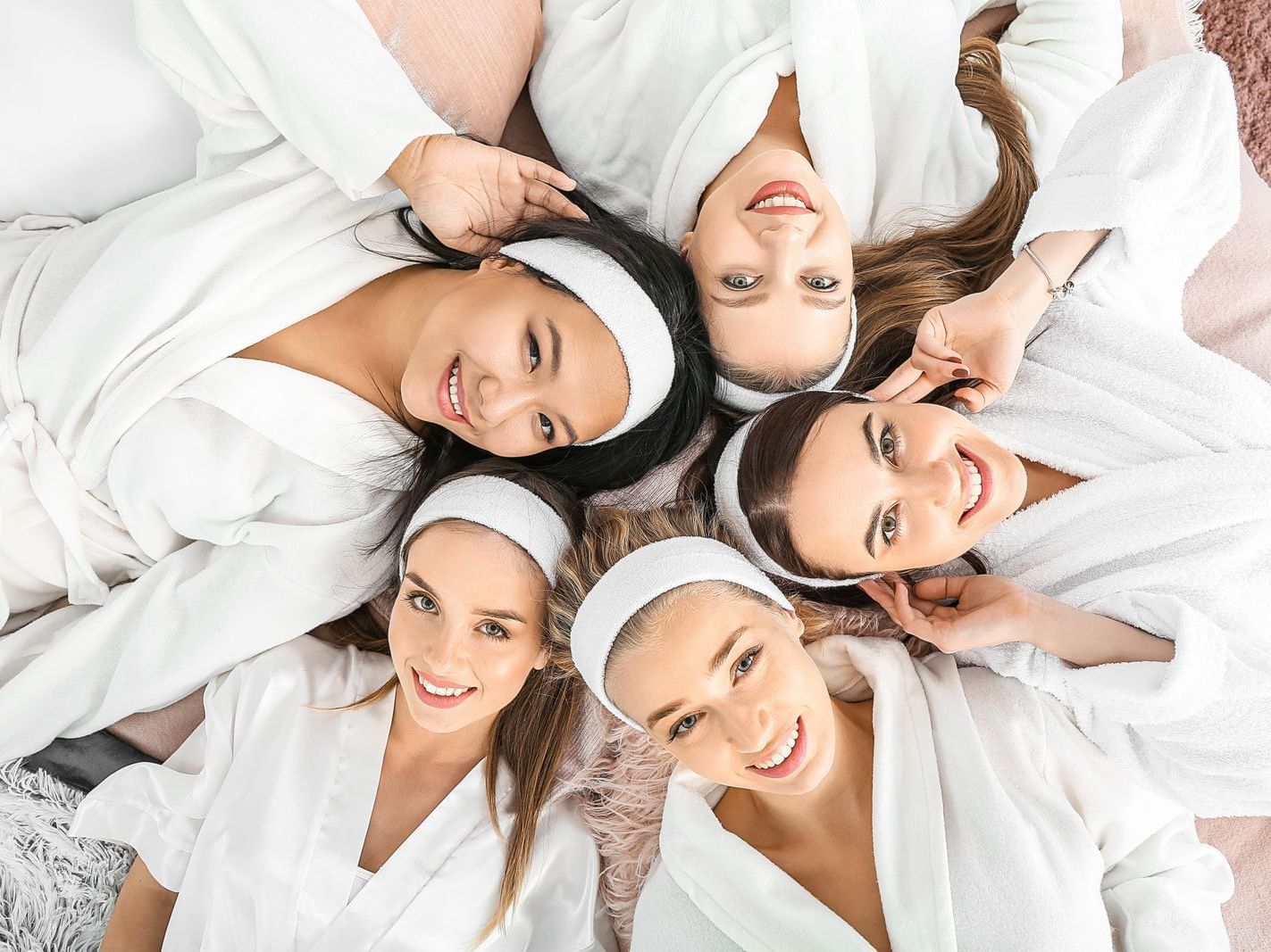 Girls laying in a circle facing the camera, La Colección