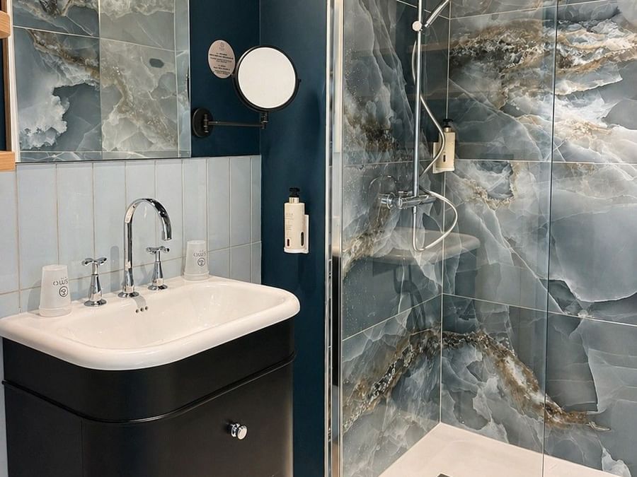Salle de bain luxueuse avec douche et lavabo à l'Osmo Hôtel de Chantepie.